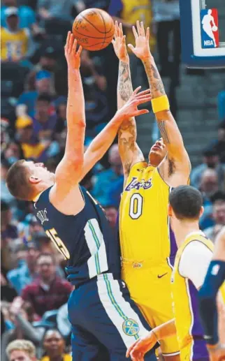  ?? David Zalubowski, The Associated Press ?? Nuggets center Nikola Jokic is blocked from scoring by the Lakers’ Kyle Kuzma during the first half of Friday night’s game at the Pepsi Center. Jokic went into Friday with season averages of 17.1 points and 10.5 rebounds per game.