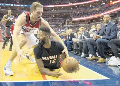  ?? PABLO MARTINEZ MONSIVAIS/AP ?? Heat forward James Johnson recovers a loose ball against Wizards guard Bojan Bogdanovic during the first half. Johnson finished with 15 points and also scored the game-winning shot on a driving, spinning finger-roll layup with 11 seconds to play.