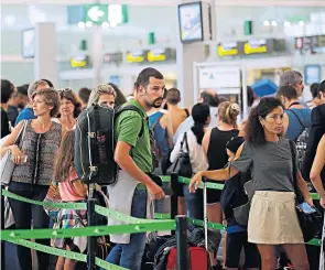  ??  ?? Passengers wait to pass the security control at the Barcelona airport in Spain yesterday