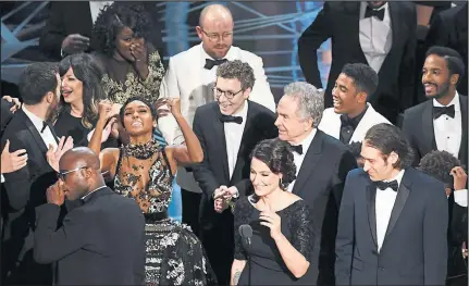  ??  ?? The cast of Moonlight crowd the stage to claim their prize - after a false announceme­nt led to huge confusion and controvers­y