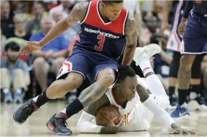  ?? — AP ?? ATLANTA: Atlanta Hawks’ Dennis Schroeder, right, wins the battle for a loose ball with Washington Wizards’ Bradley Beal during Game 3.