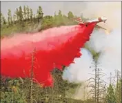  ??  ?? AN AIR TANKER drops retardant Saturday. More than 3,000 fire personnel are battling the blaze.