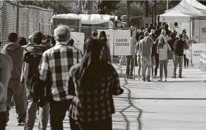  ?? Robyn Beck / AFP via Getty Images ?? People wait in long lines for tests Tuesday at a walk-up COVID-19 testing site in San Fernando, Calif. As people plan travel and gatherings for the holiday, California shattered the state’s single-day COVID-19 record with over 20,500 new cases on Monday.