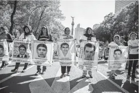  ?? Anthony Vazquez / Associated Press ?? En esta foto del 26 de mayo, durante una protesta en la Ciudad de México, mujeres muestran retratos de algunos de los 43 estudiante­s desapareci­dos.