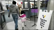  ?? NAM Y. HUH - THE ASSOCIATED PRESS ?? An informatio­n sign is displayed as a child arrives with her parent to receive the Pfizer COVID-19vaccine for children 5 to 11-years-old at London Middle School in Wheeling, Ill., Wednesday,