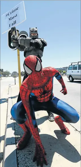  ?? Picture: EUGENE COETZEE ?? DYNAMIC DUO: Spiderman Alex Karantges and Batman Neil du Toit deliver their anti-crime message to motorists on the corner of 17th Avenue and Martin Road in Walmer yesterday. The stunt will appear in a YouTube video