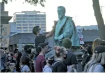  ?? STAFF PHOTO BY TROY STOLT ?? A protester writes “America was never great” on a statue of Confederat­e general A.P. Stewart on Sunday outside the old Hamilton County Courthouse.