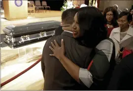  ?? JULIO CORTEZ — THE ASSOCIATED PRESS ?? Maya Rockeymoor­e Cummings, right, widow of U.S. Rep. Elijah Cummings, hugs a supporter near the casket containing the body of her husband during a viewing service Wednesday at Morgan State University in Baltimore.