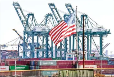  ?? MARK RALSTON/AFP ?? The US flag flies over Chinese shipping containers unloaded at the Port of Long Beach, in Los Angeles County.