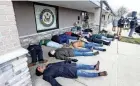  ?? PHOTOS BY GREG SWIERCZ/SOUTH BEND TRIBUNE ?? People gather in a “die-in” Wednesday, outside the offices of Indiana U.S. Rep. Rudy Yakym, R-2nd, at a prayer vigil for peace by the group Mennonite Action calling for a ceasefire in Gaza.