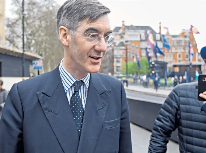  ??  ?? Jacob Rees-mogg, pictured below as he walks past Steve Bray, an anti-brexit activist, has announced that he will vote in support of Theresa May’s Brexit deal