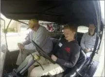  ??  ?? Alan Bennett, sitting behind the wheel, listens as 92-year-old instructor Jim Brand provides guidance on how to drive the Model T at the Gilmore Car Museum in Hickory Corners, Mich. Bennett, who is 12, is among the more than 500 people this year who...