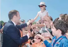  ??  ?? French President Emmanuel Macron with children during a ceremony marking the 77th anniversar­y of late French General Charles de Gaulle’s appeal of June 18, 1940, at the Mont Valerien memorial in Suresnes, outside of Paris, on Sunday. — AFP