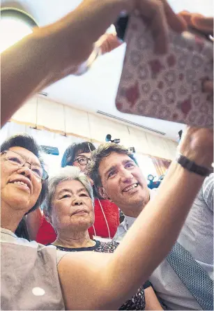  ?? NATHAN DENETTE/THE CANADIAN PRESS ?? Prime Minister Justin Trudeau, right, appeases his fans at Mon Sheong Court in Richmond Hill, Ont., on July 20. Trudeau’s a charter member of Canada’s elite ... but also a bona fide celebrity.