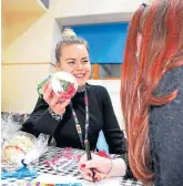  ??  ?? Youth worker Andie-Jasmin Watson helps one of the kids make a bauble.