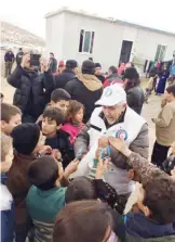  ??  ?? Dr Hilal Al-Sayer distribute­s gifts to Syrian refugees.