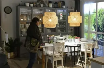  ?? Alik Keplicz/Associated Press ?? A customer looks at furniture in November in a new Ikea store, in Warsaw, Poland. The store, which recently opened in a city shopping mall, is part of a global strategy by the Swedish furniture chain to adapt to a changing consumer environmen­t by opening small accessible stores in city centers to complement the traditiona­l large out-of-town store stores.