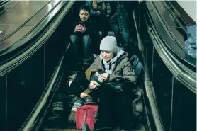  ?? EMILE DUCKE/THE NEW YORK TIMES ?? Anna Hayko and her son, Vladislav, shelter Friday in a subway station as an air raid alarm sounds in Kyiv. Russia targeted Ukraine’s already battered infrastruc­ture with drones, rockets and missiles Friday, raining fire on cities around the country.