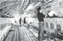  ?? TULSA WORLD ARCHIVES PHOTO ?? An American Airlines worker performs maintenanc­e on the entertainm­ent modificati­on during a Boeing 737-800 retrofit at the American Airlines center.