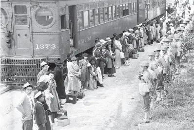  ?? AP ?? In this photo provided by the National Archives, Japanese Americans from San Pedro, California, arrive at the Santa Anita Assembly Center in Arcadia, California, on April 5, 1942.
