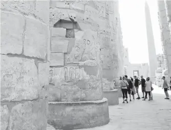  ??  ?? Massive columns tower over visitors in the Karnak Temple complex, where celebratio­ns honoured Amun, an Egyptian god of life.