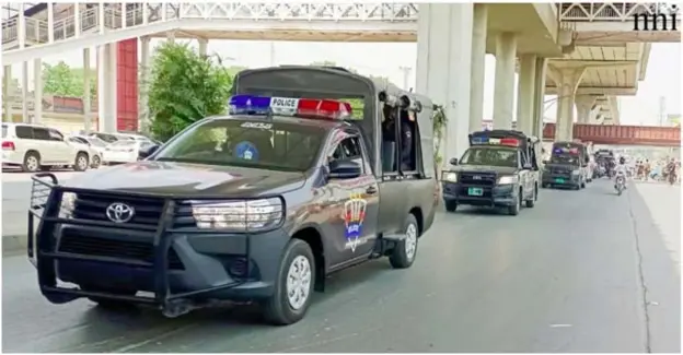  ?? ?? Rawalpindi: The flag march conducted by the administra­tion to maintain law and order on May 9 is passing through Murree Road.