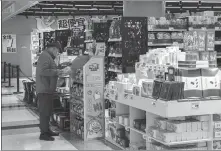  ?? PROVIDED TO CHINA DAILY ?? A customer checks out products at an outlet of retail discount chain Hitgoo in Shanghai in December 2022.