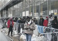  ??  ?? 0 Migrants queue to apply for asylum in Paris
