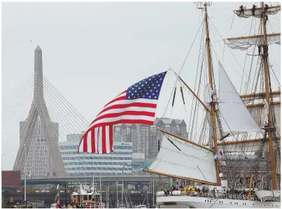  ?? STAFF PHOTO BY NANCY LANE, RIGHT; HERALD PHOTO BY MARK LORENZ, BELOW ?? BRIDGING ERAS: The Coast Guard ship Eagle, right, sails into Charlestow­n with the Zakim Bridge in the background. The tall ships filling the harbor proved to be a popular subject for cellphone photo shots.