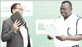  ?? (Courtesy pics) ?? Appointed Councillor Absalom Ndlovu (L) being sworn in as the interim mayor by Pigg’s Peak Police Station Commander Superinten­dent Dumisane Nzalo.