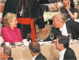  ?? SPENCER PLATT/GETTY IMAGES ?? Hillary Clinton speaks briefly with Donald Trump on Thursday during the annual Alfred E. Smith Memorial Foundation Dinner, a benefit at the Waldorf Astoria in New York City.