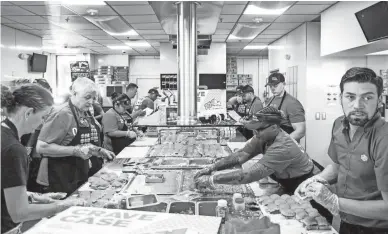  ?? ELI IMADALI/THE REPUBLIC ?? Employees make food at the opening of the first White Castle in Arizona near Scottsdale on Oct. 23.