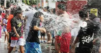  ??  ?? Bucketload­s of fun: Revellers splashing each other with water during the celebratio­ns at the Portuguese Settlement in Ujong Pasir yesterday,