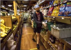  ?? ALEJANDRO A. ALVAREZ/THE PHILADELPH­IA INQUIRER ?? Grocery clerk Matt Sawyer organizes containers used to keep home-delivery and curbside pickup items together at Weavers Way Co-op in Philadelph­ia's Mount Airy section.