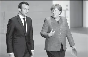  ?? AP/ MICHAEL SOHN ?? New French President Emmanuel Macron and German Chancellor Angela Merkel arrive Monday for a joint news conference as part of a meeting in Berlin during Macron’s fi rst foreign trip after his Sunday inaugurati­on.