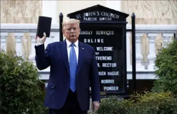  ?? Patrick Semansky/Associated Press ?? President Donald Trump holds a Bible as he visits Monday outside St. John’s Church across Lafayette Park from the White House in Washington. Part of the church was set on fire during protests Sunday night.