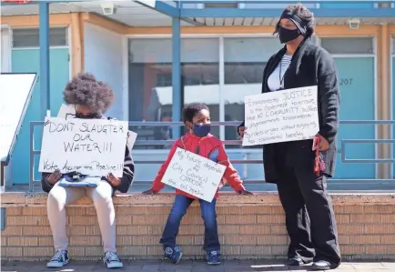  ?? BRANDON DAHLBERG/FOR USA TODAY NETWORK ?? Kizzy Jones of Memphis Community Against the Pipeline hold signs outside the National Civil Rights Museum during a rally in February against the constructi­on of the Byhalia Connection Pipeline.