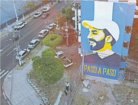  ?? ?? Um mural com o rosto do presidente Bukele na empena de um edifício em São Salvador.