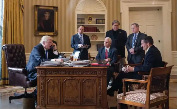  ?? DREW ANGERER/GETTY IMAGES ?? President Donald Trump speaks on the phone with Russian President Vladimir Putin with his top advisers around him in the Oval Office on Saturday. Trump’s first week was anything but dull.