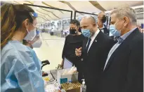  ?? (Haim Zach/GPO) ?? PRIME MINISTER Naftali Bennett, Health Minister Nitzan Horowitz (right) and Transporta­tion Minister Merav Michaeli talk with medical technician­s at Ben-Gurion Airport yesterday.
