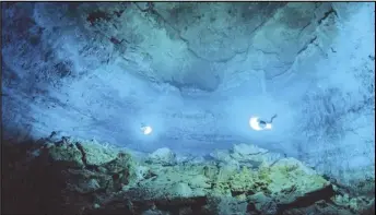  ?? ASSOCIATED PRESS ?? In this undated photo released by Mexico's National Institute of Anthropolo­gy and History, INAH, scuba divers explore the Hoyo Negro underwater cave, or cenote, in Tulum, Quintana Roo state, Mexico, where according INAH, a skeleton almost 13,000 years old of a prehistori­c young woman was found, making it the oldest and most complete found in the Americas.