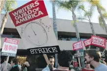  ?? THE ASSOCIATED PRESS ?? Members of the Writers Guild of America (here at NBC Studios in Burbank, Calif.) went on strike for 100 days in 2007-08.