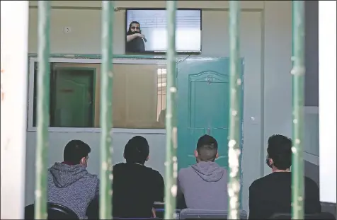  ?? (AP/Thanassis Stavrakis) ?? Inmates sitting inside a room watch a recorded music lesson in Avlona prison north of Athens.