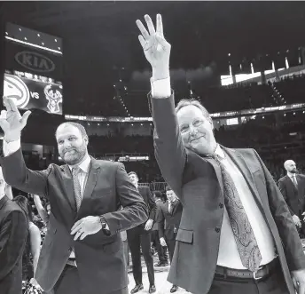  ?? AP PHOTO/CURTIS COMPTON ?? Former Atlanta Hawks coach Mike Budenholze­r, right, waves to players and fans as he returns as the Milwaukee Bucks coach to State Farm Arena on Sunday in Atlanta.