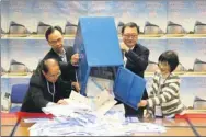  ?? EDMOND TANG / CHINA DAILY ?? Electoral Affairs Commission Chairman Barnabas Fung Wah (second right) and Secretary for Constituti­onal and Mainland Affairs Patrick Nip Tak-kuen (second left) open a ballot box at the counting station at Jockey Club Government Secondary School, Kowloon Tong.