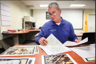  ?? GABRIELA CAMPOS/THE NEW MEXICAN ?? Detective Tony Trujillo goes through a folder Thursday complete with maps, photos and reports for Teal Pittington. Pittington went missing in 1984, and her body was found in a culvert south of Santa Fe months later. She’d been raped and strangled.