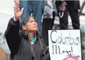  ?? PHOTO BY ELAINE THOMPSON/AP ?? Ferntree, a member of the Cowichan Tribes, joins in a prayer given during a protest against Columbus Day in Seattle in 2011.