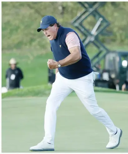  ??  ?? Phil Mickelson of the US Team celebrates on the 18th green after he and teammate Kevin Kisner defeated Internatio­nal Team's Australian­s Marc Leishman and Jason Day 1 up during the fourball matches of the Presidents Cup at Liberty National Golf Club on...