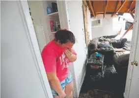  ?? Gerald Herbert, The Associated Press ?? Kaylee O’Brien cries in her apartment after four pine trees fell on it Wednesday as Hurricane Michael hit Panama City, Fla.