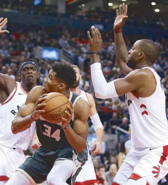  ?? REUTERS ?? Toronto Raptors forward Pascal Siakam (43) and Raptors forward CJ Miles (0) prepare to block an undergoal try by Milwaukee Bucks forward Giannis Antetokoun­mpo (34) at Scotiabank Arena.